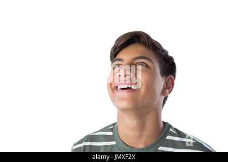 Smiling teenage boy looking away against white background Banque D'Images