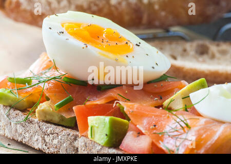 Pain au levain grillé à la tomate, l'avocat, du saumon fumé et d'œufs fraîchement bouillie. Banque D'Images