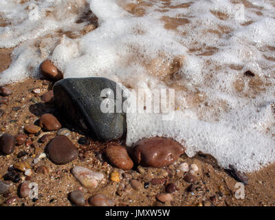 Tours sur l'eau douce, sur une plage de galets arrondis. Banque D'Images