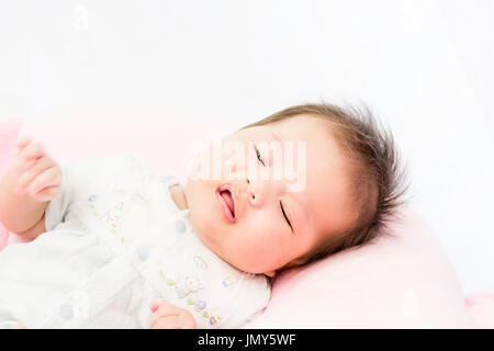 Portrait d'un adorable petit bébé fille bébé allongé sur le dos sur l'oreiller Banque D'Images