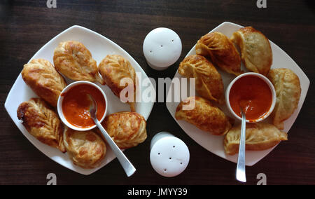 Poêlée de légumes, sauce au fromage blanc avec momos en plaques sur une table en bois. Banque D'Images