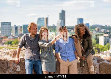 Jeune fille pointant la direction à ses amis à l'horizon de la ville sur l'arrière-plan. Concept Banque D'Images