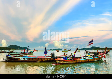 Phuket, Thaïlande - 17 août 2014 : bateaux à longue queue et vitesse des bateaux utilisés pour la pêche et des excursions touristiques amarré dans la baie au coucher du soleil au large de la plage de Rawai Banque D'Images