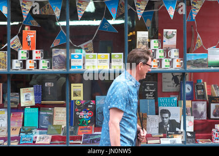 Hay on Wye homme marche passé l'affichage de la fenêtre librairie Galles UK Banque D'Images