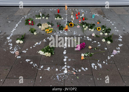 Hambourg, Allemagne. 29 juillet, 2017. Fleurs et bougies en forme d'un signe de la paix se trouvent sur le trottoir en face du supermarché où un homme a tué une autre personne et en a blessé six autres personnes à Hambourg, Allemagne, 29 juillet 2017. Photo : Markus Scholz/dpa/Alamy Live News Banque D'Images