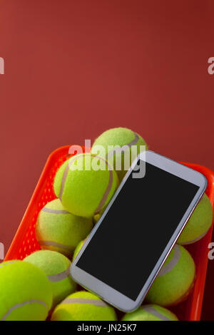 Smartphone de balles de tennis et de basket sur fond marron Banque D'Images