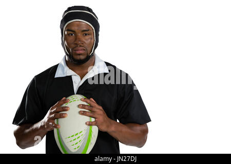 Portrait de joueur de rugby masculin portant helmet holding boule tout standing against white background Banque D'Images