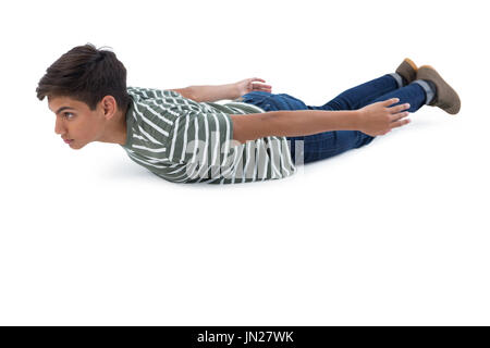 Teenage boy lying on the floor against white background Banque D'Images