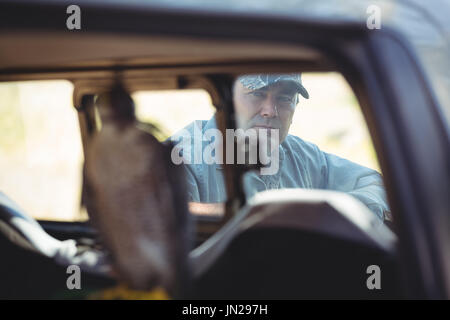 Portrait de l'homme à la voiture à longue queue dans une fenêtre Banque D'Images