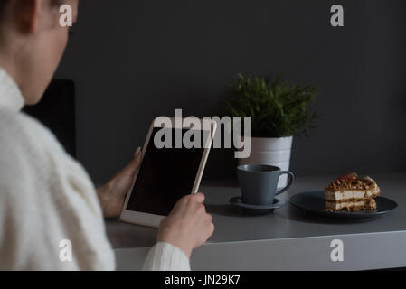 Close up of woman using digital tablet à table pendant le petit-déjeuner Banque D'Images