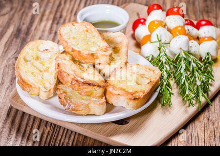 Fromage et pain tomate bouchées sur des brochettes de romarin Banque D'Images