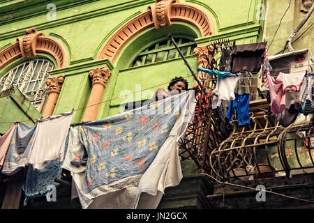 Une femme cubaine se bloque sur la blanchisserie balcon garde-fous à La Havane, Cuba. Banque D'Images