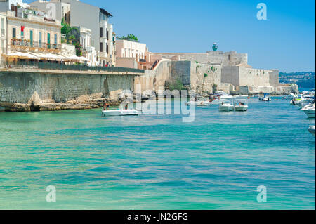 Côte est de la Sicile, vue en été des bateaux de loisirs amarrés sous le mur de la mer dans le port d'Ortigia, Syracuse (Syracuse), Sicile. Banque D'Images