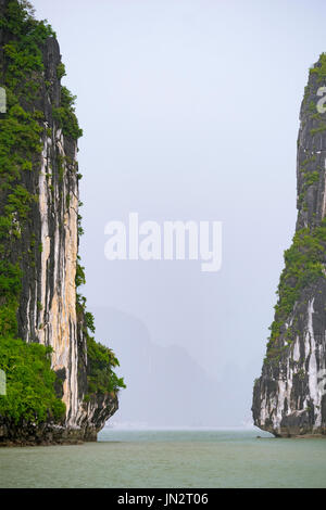 Écart entre deux karsts calcaire sur un jour brumeux dans la baie d'Halong, Vietnam Banque D'Images