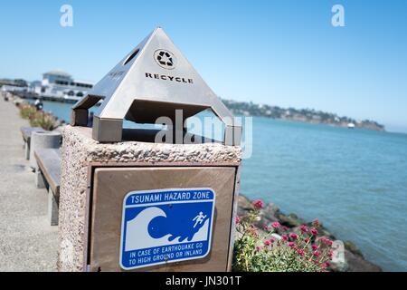 La signalisation sur le côté d'une poubelle lit des risques de tsunami sur Zone Bridgeway Road dans la baie de San Francisco ville de Sausalito, Californie, le 29 juin 2017. Les tsunamis sont une menace pour la région de la Baie d'activité sismique. Banque D'Images