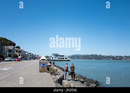 Deux hommes à pied le long d'une digue et manger des glaces sur Bridgeway Road dans la région de la baie de San Francisco, ville de Sausalito, Californie, le 29 juin 2017. Banque D'Images