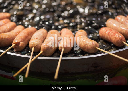 Barbecue de saucisses sur des pierres - l'alimentation de rue chinois Banque D'Images