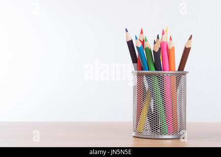 Wire Mesh panier plein de crayons de couleur dans un concept d'art, la créativité et l'éducation sur une table en bois avec copie espace Banque D'Images