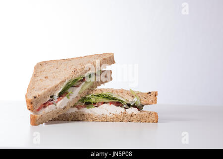 Un frais, sain du pain sandwich salade de poulet coupé en triangles et empilés sur un arrière-plan uni, blanc avec copie espace. Banque D'Images