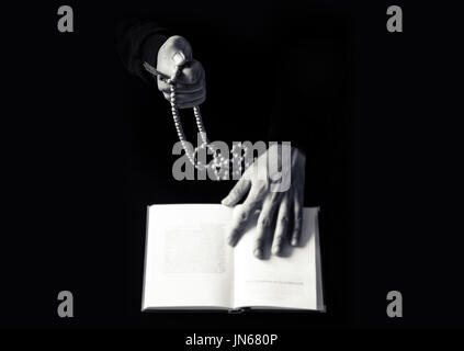 Les jeunes mains qui prient avec un chapelet et la Sainte Bible. La religion concept photo en noir et blanc Banque D'Images