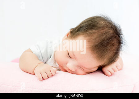 Portrait d'un adorable petit infant baby girl le bâillement avant de dormir sur le lit à l'intérieur Banque D'Images