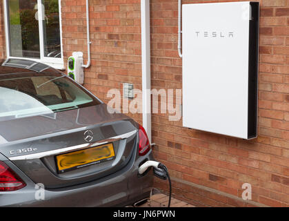 Une Mercedes Classe C voiture électrique hybride en cours de charge ( via un chargeur de Rolec) à partir de l'énergie solaire stockée dans un étalages muraux Tesla 2, une batterie de 14kWh. Tous les fait fr Banque D'Images