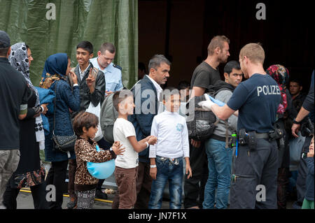 Passau, Allemagne - le 2 août 2015 : un officier de police allemand s'occupe des réfugiés à la zone d'enregistrement à Passau, Bavière. Banque D'Images