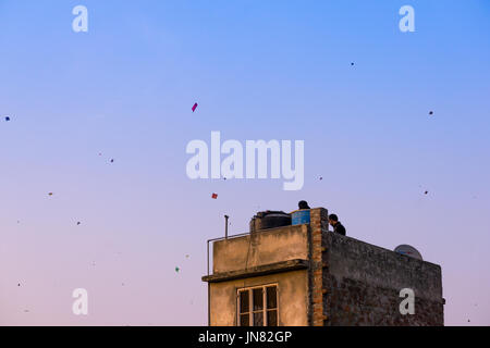 Jaipur, Inde - 14 Jan 2017 : les familles avec des cerfs-volants sur les toits de leurs bâtiments en briques anciennes dans la vieille ville de Jaipur. C'est un sport populaire de Makar Sankranti et Jour de l'indépendance. Banque D'Images