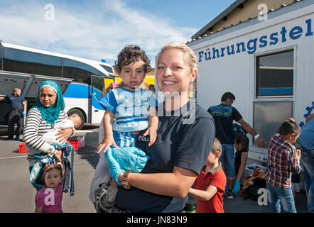 Passau, Allemagne - 1 août 2015 : Un Königis allemand policewoman (Juliane) en prenant soin d'un jeune enfant réfugié (Ahand) à partir de la Syrie. Banque D'Images