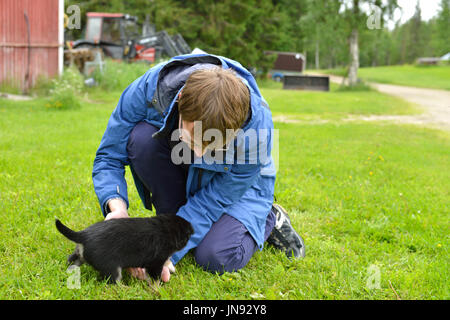 Jeune homme jouant avec chiot mensuel de Laponie chien Rennes Banque D'Images