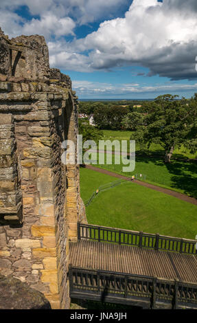 Vue sur les murs du château, l'entrée et la lande, château médiéval de Dirleton du XIIIe siècle, East Lothian, Écosse, Royaume-Uni le jour d'été avec des cumulus Banque D'Images