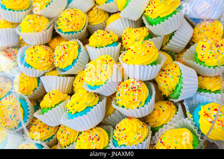 Pile de papier dans des gâteaux colorés paniers avec crème jaune Banque D'Images