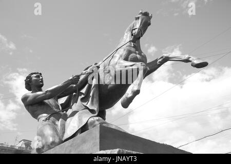 Dresseurs de chevaux sculpture (1851) de Peter Klodt sur pont Anitchkov à Saint-Pétersbourg, Russie. Le noir et blanc Banque D'Images