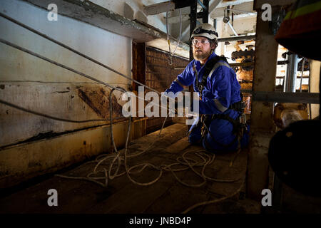 Une corde industriel technicien d'accès mise en place d'un système de transport recsue, vêtu d'une combinaison bleu. crédit : lee ramsden / alamy Banque D'Images