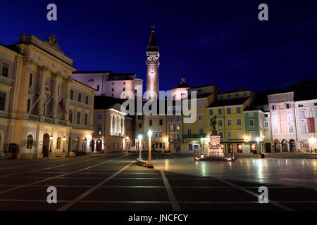 La place Tartini Piran Slovénie avec l'Hôtel de Ville, l'église paroissiale de Saint Georges avec beffroi et baptistère, maison vénitienne, statue de Tartini, au crépuscule crépuscule Banque D'Images