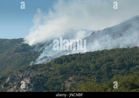 L'extinction de l'hélicoptère d'immenses feux de forêts sur les montagnes près de Herceg Novi et la baie de Kotor au Monténégro Banque D'Images