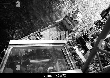 Image en noir et blanc d'une mer du Nord Industrie pétrolière et gazière, l'approvisionnement à partir de la grue en tenant le navire de ravitaillement. crédit : lee ramsden / alamy Banque D'Images