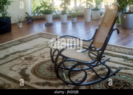 Fauteuil à bascule en osier marron dans le hall Banque D'Images