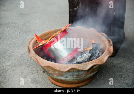 Les gens brûlent joss paper or et l'argent pour le culte du papier avec du papier fait à ressembler à de l'argent et brûlés comme offrande sacrificielle pour prier Dieu et memo Banque D'Images