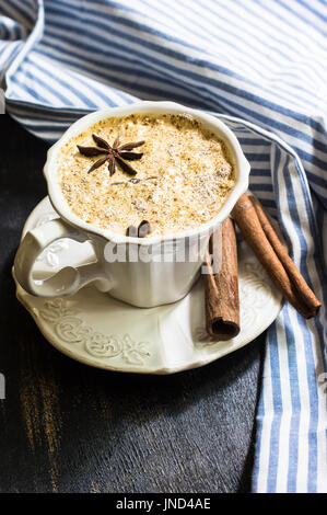 Tasse de cappuccino avec étoile d'anis et d'épices cannelle sur table en bois rustique Banque D'Images