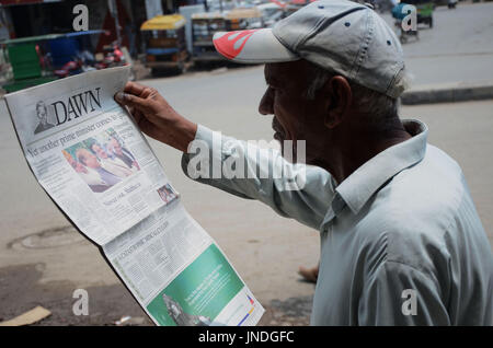 L'homme lit un journal pakistanais avec front page news de Pakistanais renversé l'ancien Premier Ministre Nawaz Sharif.Cour suprême du Pakistan le 28 Juillet Le Premier Ministre Nawaz Sharif exclu de la vie publique sur les allégations de corruption, d'exécution d'une décision qui exclut de la Premiership pour la troisième fois. La décision plonge le pays dans les troubles politiques environ un an avant les élections générales programmées qui aurait vu Sharif devenir le premier premier ministre pakistanais, d'achever un cycle complet de cinq ans. (Photo par Rana Sajid Hussain/Pacific Press) Banque D'Images