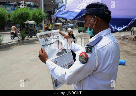 L'homme lit un journal pakistanais avec front page news de Pakistanais renversé l'ancien Premier Ministre Nawaz Sharif.Cour suprême du Pakistan le 28 Juillet Le Premier Ministre Nawaz Sharif exclu de la vie publique sur les allégations de corruption, d'exécution d'une décision qui exclut de la Premiership pour la troisième fois. La décision plonge le pays dans les troubles politiques environ un an avant les élections générales programmées qui aurait vu Sharif devenir le premier premier ministre pakistanais, d'achever un cycle complet de cinq ans. (Photo par Rana Sajid Hussain/Pacific Press) Banque D'Images