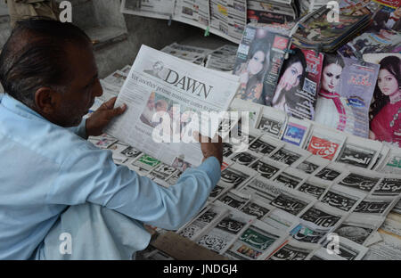 L'homme lit un journal pakistanais avec front page news de Pakistanais renversé l'ancien Premier Ministre Nawaz Sharif.Cour suprême du Pakistan le 28 Juillet Le Premier Ministre Nawaz Sharif exclu de la vie publique sur les allégations de corruption, d'exécution d'une décision qui exclut de la Premiership pour la troisième fois. La décision plonge le pays dans les troubles politiques environ un an avant les élections générales programmées qui aurait vu Sharif devenir le premier premier ministre pakistanais, d'achever un cycle complet de cinq ans. (Photo par Rana Sajid Hussain/Pacific Press) Banque D'Images