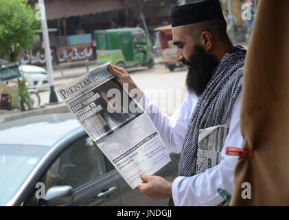 L'homme lit un journal pakistanais avec front page news de Pakistanais renversé l'ancien Premier Ministre Nawaz Sharif.Cour suprême du Pakistan le 28 Juillet Le Premier Ministre Nawaz Sharif exclu de la vie publique sur les allégations de corruption, d'exécution d'une décision qui exclut de la Premiership pour la troisième fois. La décision plonge le pays dans les troubles politiques environ un an avant les élections générales programmées qui aurait vu Sharif devenir le premier premier ministre pakistanais, d'achever un cycle complet de cinq ans. (Photo par Rana Sajid Hussain/Pacific Press) Banque D'Images