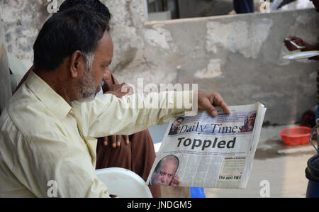 L'homme lit un journal pakistanais avec front page news de Pakistanais renversé l'ancien Premier Ministre Nawaz Sharif.Cour suprême du Pakistan le 28 Juillet Le Premier Ministre Nawaz Sharif exclu de la vie publique sur les allégations de corruption, d'exécution d'une décision qui exclut de la Premiership pour la troisième fois. La décision plonge le pays dans les troubles politiques environ un an avant les élections générales programmées qui aurait vu Sharif devenir le premier premier ministre pakistanais, d'achever un cycle complet de cinq ans. (Photo par Rana Sajid Hussain/Pacific Press) Banque D'Images