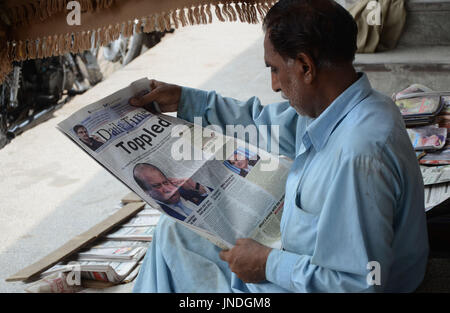 L'homme lit un journal pakistanais avec front page news de Pakistanais renversé l'ancien Premier Ministre Nawaz Sharif.Cour suprême du Pakistan le 28 Juillet Le Premier Ministre Nawaz Sharif exclu de la vie publique sur les allégations de corruption, d'exécution d'une décision qui exclut de la Premiership pour la troisième fois. La décision plonge le pays dans les troubles politiques environ un an avant les élections générales programmées qui aurait vu Sharif devenir le premier premier ministre pakistanais, d'achever un cycle complet de cinq ans. (Photo par Rana Sajid Hussain/Pacific Press) Banque D'Images