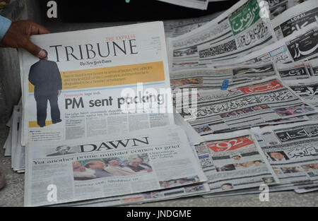 L'homme lit un journal pakistanais avec front page news de Pakistanais renversé l'ancien Premier Ministre Nawaz Sharif.Cour suprême du Pakistan le 28 Juillet Le Premier Ministre Nawaz Sharif exclu de la vie publique sur les allégations de corruption, d'exécution d'une décision qui exclut de la Premiership pour la troisième fois. La décision plonge le pays dans les troubles politiques environ un an avant les élections générales programmées qui aurait vu Sharif devenir le premier premier ministre pakistanais, d'achever un cycle complet de cinq ans. (Photo par Rana Sajid Hussain/Pacific Press) Banque D'Images