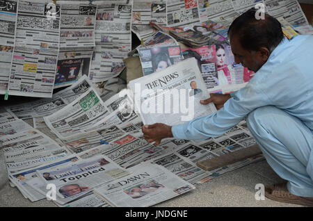 L'homme lit un journal pakistanais avec front page news de Pakistanais renversé l'ancien Premier Ministre Nawaz Sharif.Cour suprême du Pakistan le 28 Juillet Le Premier Ministre Nawaz Sharif exclu de la vie publique sur les allégations de corruption, d'exécution d'une décision qui exclut de la Premiership pour la troisième fois. La décision plonge le pays dans les troubles politiques environ un an avant les élections générales programmées qui aurait vu Sharif devenir le premier premier ministre pakistanais, d'achever un cycle complet de cinq ans. (Photo par Rana Sajid Hussain/Pacific Press) Banque D'Images