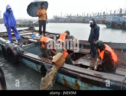 Jinjiang, Chine. 30 juillet, 2017. Aider les pêcheurs locaux policiers vidanger l'eau sur un bateau de pêche à un quai à Jinjiang, dans le sud-est de la province de Fujian en Chine, le 30 juillet 2017. Le typhon Nesat, le neuvième typhon de l'année, a touché terre à Fujian dimanche matin. Sans répit, le typhon Haitang, la dixième typhon de l'année, était prévu à la terre dans le sud de Taïwan dimanche soir et faire un second atterrissage en quelque part entre Xiapu et Jinjiang dans la province du Fujian lundi matin, selon le Centre météorologique national. Source : Xinhua/Alamy Live News Banque D'Images