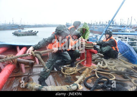 Jinjiang, Chine. 30 juillet, 2017. Aider les pêcheurs locaux policiers renforcer des bateaux de pêche à un quai à Jinjiang, dans le sud-est de la province de Fujian en Chine, le 30 juillet 2017. Le typhon Nesat, le neuvième typhon de l'année, a touché terre à Fujian dimanche matin. Sans répit, le typhon Haitang, la dixième typhon de l'année, était prévu à la terre dans le sud de Taïwan dimanche soir et faire un second atterrissage en quelque part entre Xiapu et Jinjiang dans la province du Fujian lundi matin, selon le Centre météorologique national. Source : Xinhua/Alamy Live News Banque D'Images